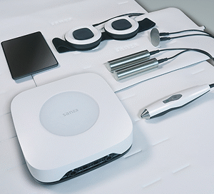 Sanza-Geräteset mit Steuergerät, Applikatoren und Zubehör neatly ausgelegt auf einer Therapieliege