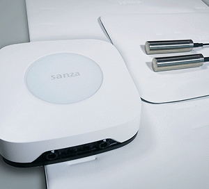 Sanza-Geräteset mit Steuergerät, Applikatoren und Zubehör neatly ausgelegt auf einer Therapieliege